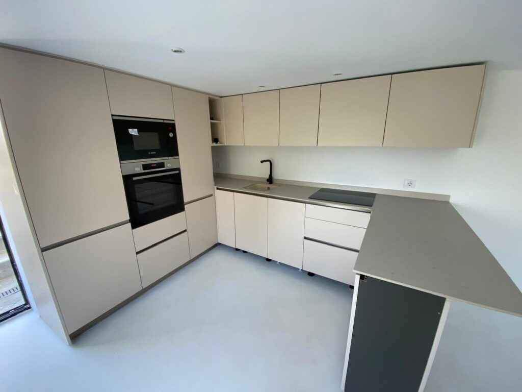 Sand-toned kitchen with peninsula in Benissa, designed and installed by Mayra Studio