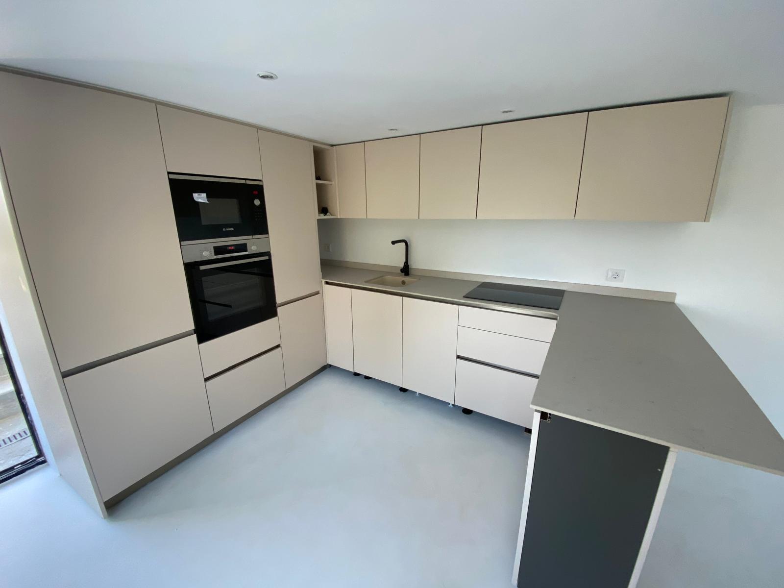 Sand-toned kitchen with peninsula in Benissa, designed and installed by Mayra Studio