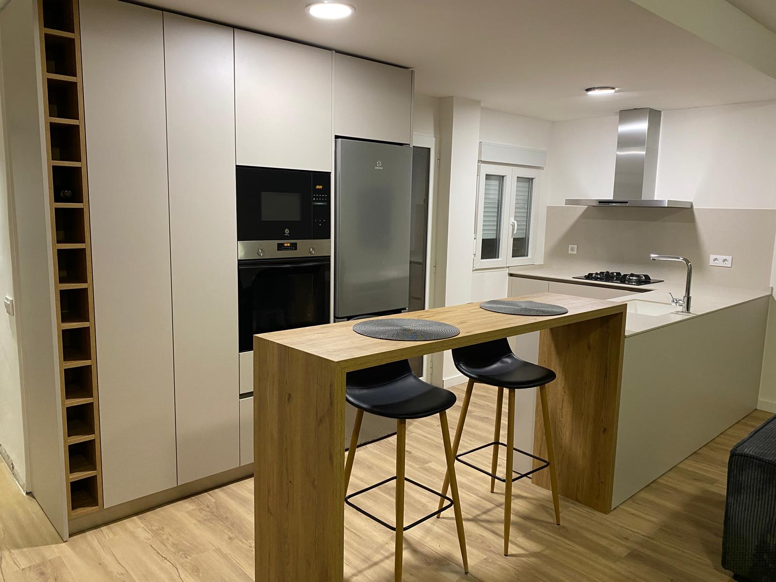 Bespoke kitchen in Gata de Gorgos with tall units, wine rack and oak breakfast bar, designed and installed by Mayra Studio