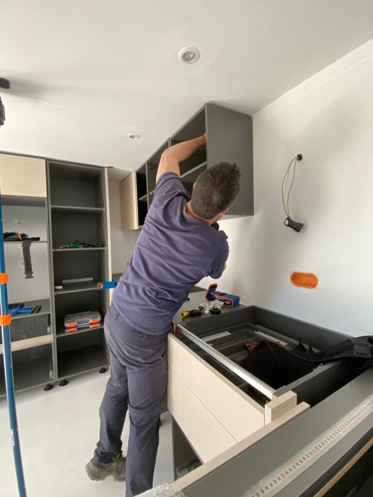 Mauro installing wall cabinets in a kitchen in Benissa